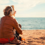 Young woman in a headphones at the beach