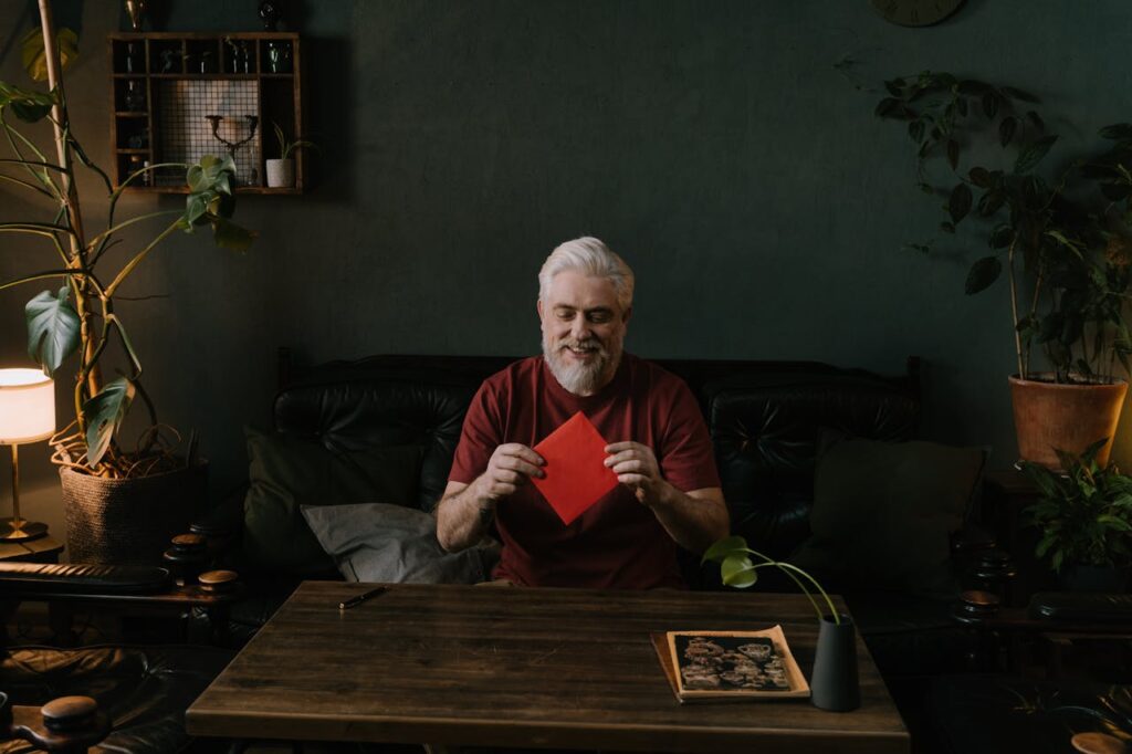 Older man sitting at a table at home surrounded by houseplants