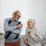 Senior couple smiling and enjoying green smoothies in a cozy kitchen setting